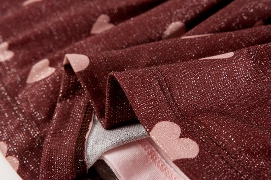 Bordeauxrode rok met roze hartjes en glitter; de binnenkant is lichtroze.