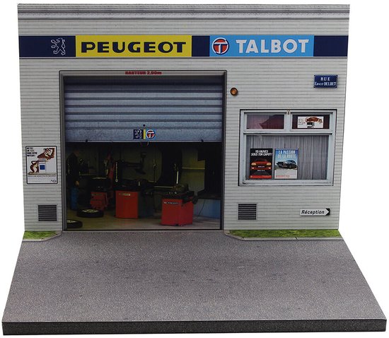 Diorama van een Peugeot Talbot garage in schaal 1:43, met een grote grijze roldeur en de merken Peugeot en Talbot boven de ingang.