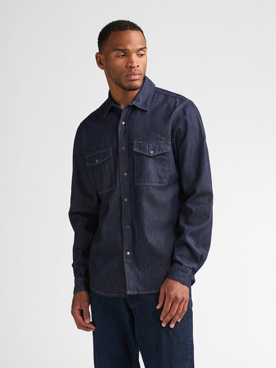 Man in donkerblauw denim overhemd met lange mouwen en twee borstzakken.