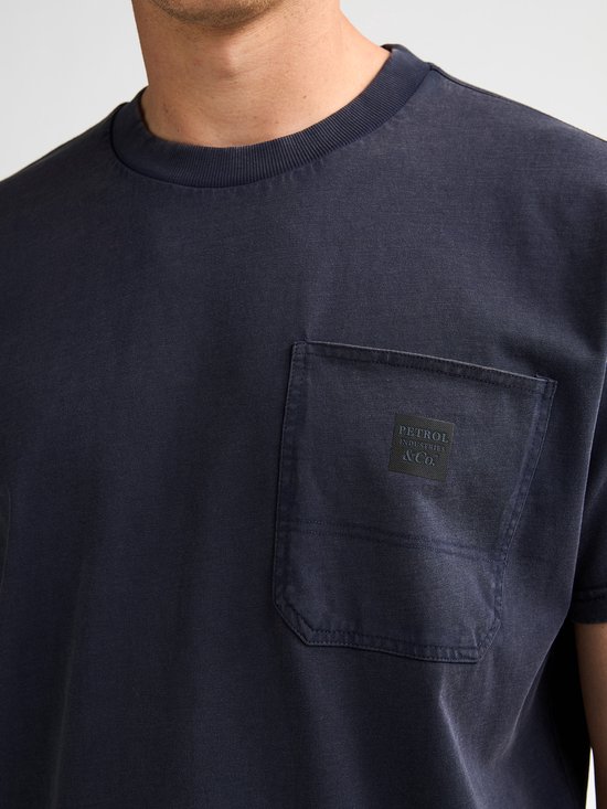 Close-up van de borstzak op het donkerblauwe T-shirt met 'Petrol Industries & Co.' logo.