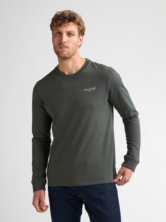 Man met een donkergroene longsleeve met kleine opdruk 'Petrol Industries' op de borst.