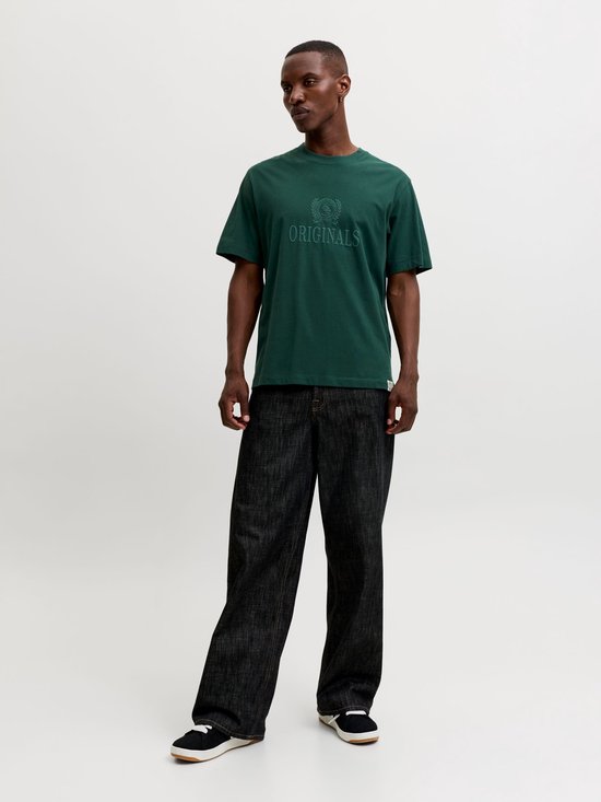 Man draagt een donkergroen Jack & Jones T-shirt en donkere jeans.