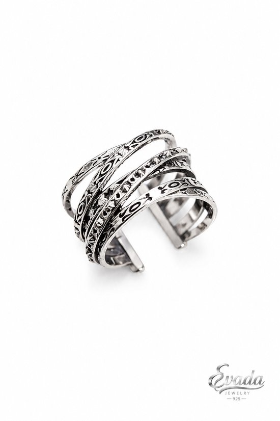 Bracelet manchette en argent avec un design superposé et oxydé aux motifs complexes.