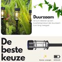Drie zwarte lantaarnpalen met filament LED in een weelderige tuin.