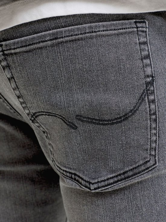 Detail van de achterzak van een grijze jeans.