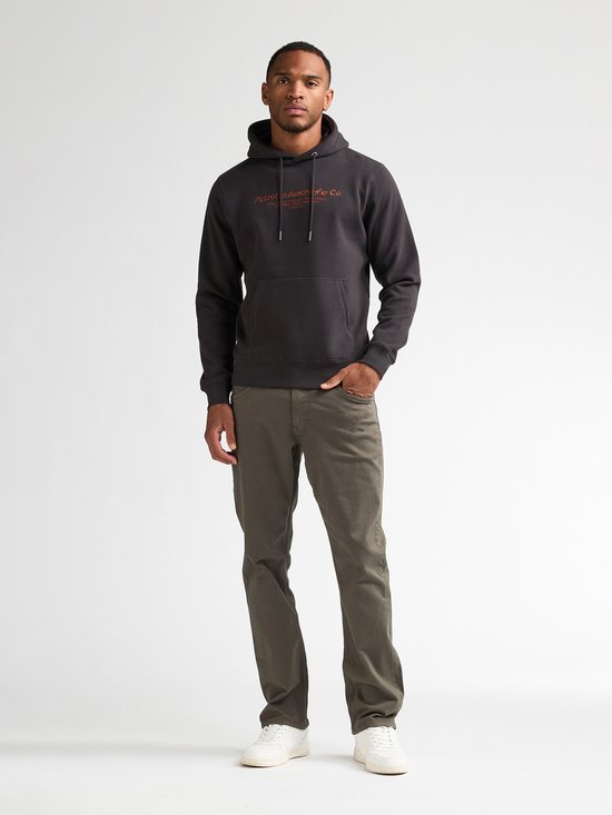 Donkere hoodie met oranje opdruk 'Petrol Industries & Co.', op een man.
