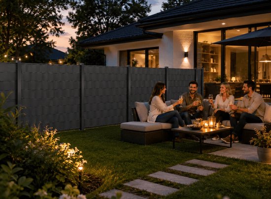 Vier vrienden genieten van een drankje op een loungebank in de tuin bij een antraciet hekwerk.