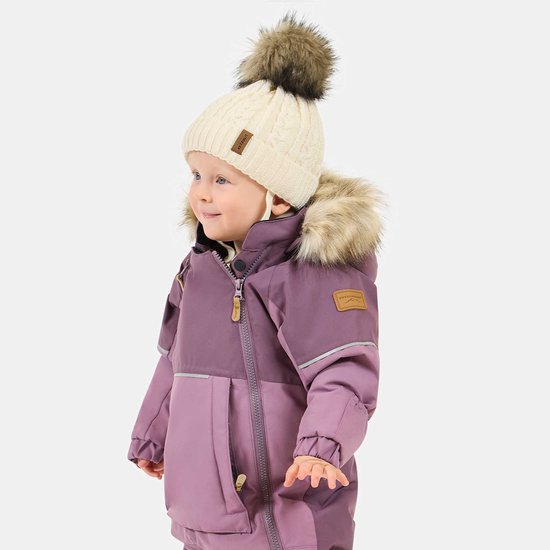Peuter draagt een paarse winteroverall, een crème muts met pompon en heeft een 'Swedemount' label op de mouw.