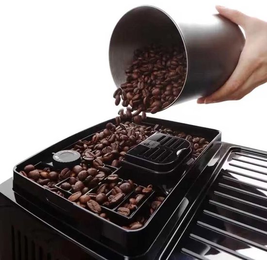 Hand vult de De'Longhi Magnifica Start met koffiebonen uit een metalen bakje.