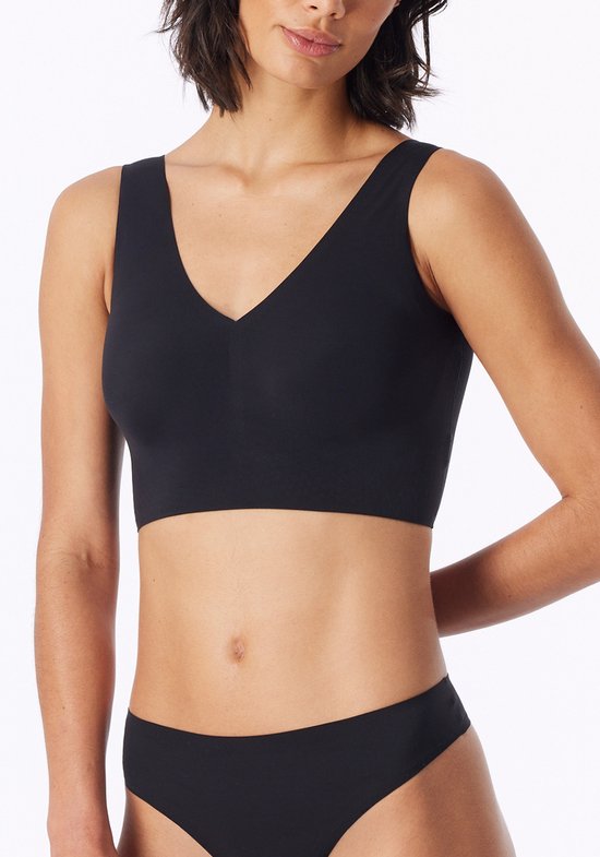 Zwarte bustier met V-hals, gedragen door een model met de hand in de rug.