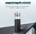 Zilverkleurige RVS schoorsteenkap met ronde openingen, geplaatst op een zwarte schoorsteen van een modern huis.