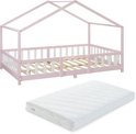 Roze kinderhuisbed met witte spijlen en een losse witte matras.