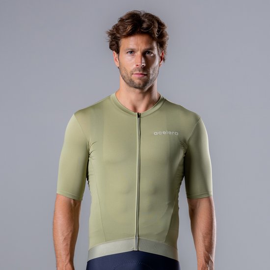 Homme vu de face, portant un maillot de cyclisme vert pistache à manches courtes, fermeture éclair et logo 'acelera'.