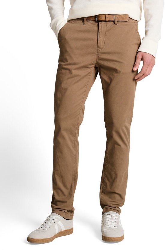 Model in een bruine chino en grijze sneakers.