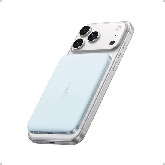 Lichtblauwe Anker powerbank magnetisch bevestigd aan de achterkant van een iPhone 17 Pro.