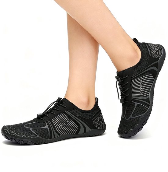 Zwarte waterschoenen met veters en grijze lijnen, op de voeten van een persoon