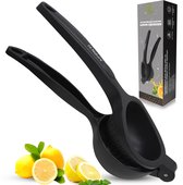 Presse-citron noir sur fond de bois avec des citrons et des feuilles de menthe.
