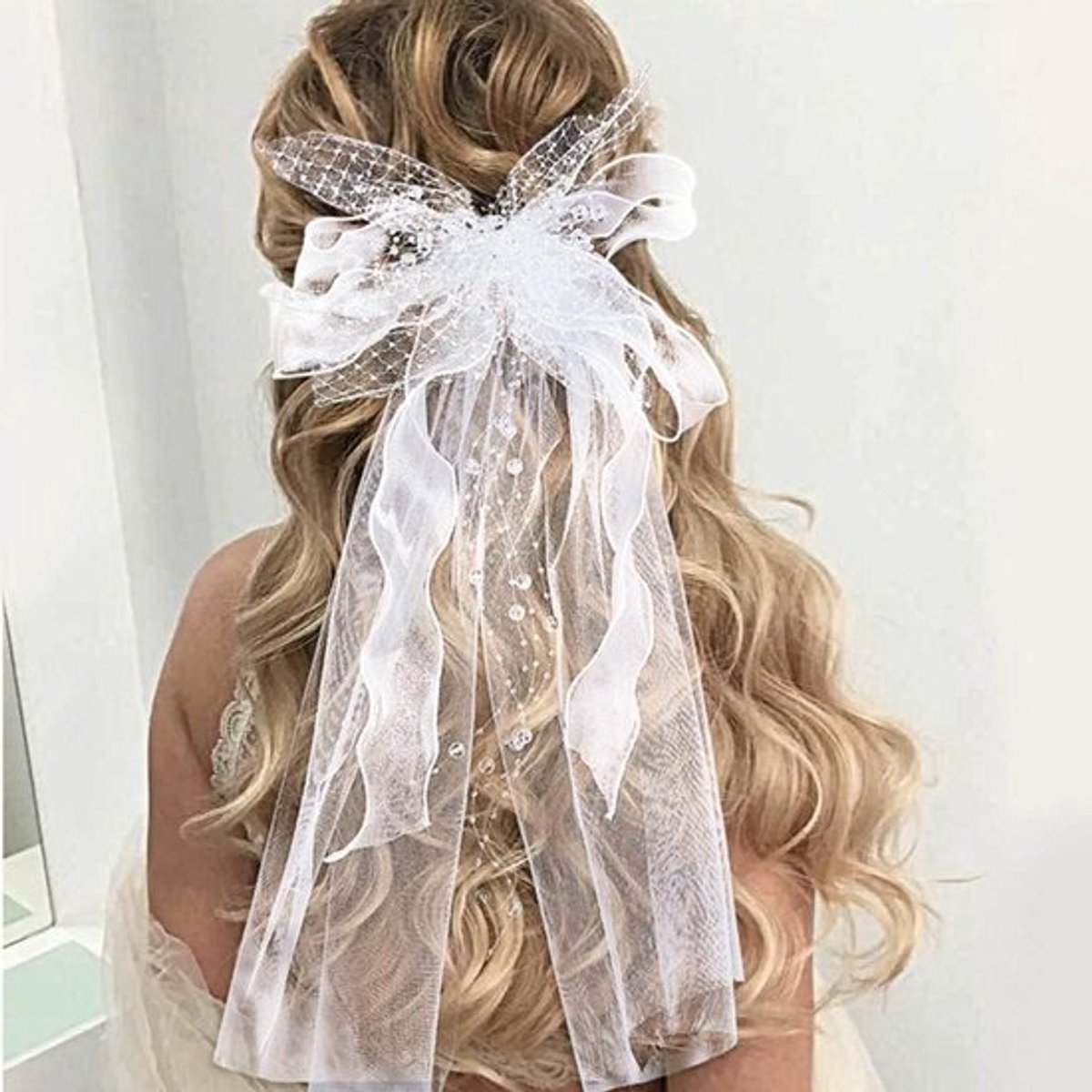 Elegante witte trouwsluier met strik en kantapplicaties, ideaal voor bruiden met een kam