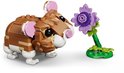Un hamster LEGO marron aux oreilles roses regarde une fleur violette.