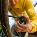 Man met gele trui houdt GoPro HERO13 Black camera bij een fietswiel.