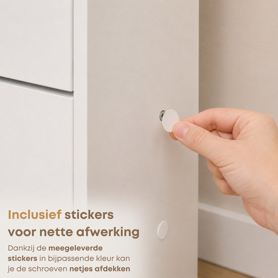Main plaçant un autocollant pour cacher une vis sur un meuble blanc.