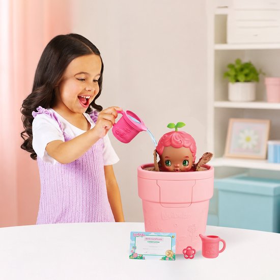 Vrolijk meisje met krullen geeft Luvibubs pop in roze pot water. Pop kijkt verbaasd, blaadjes op haar hoofd.