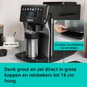 Zwart-metalen Siemens volautomaat espressomachine met grote mok en hand die lekbak verwijdert.