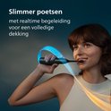 Vrouw met donkere huid en bruin haar poetst tanden met donkergroene Philips Sonicare tandenborstel. Blauwe en oranje gloed.