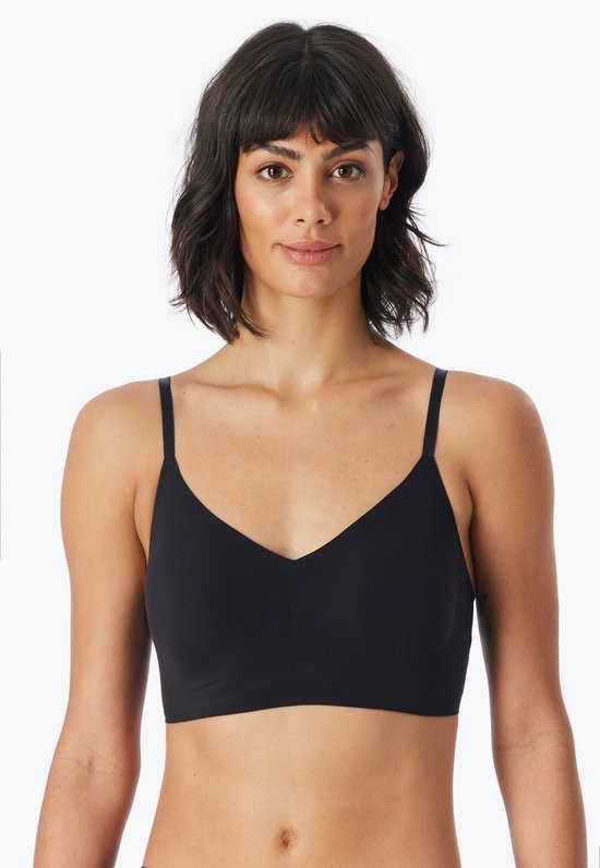 Model draagt een zwarte bustier met V-hals en dunne bandjes.