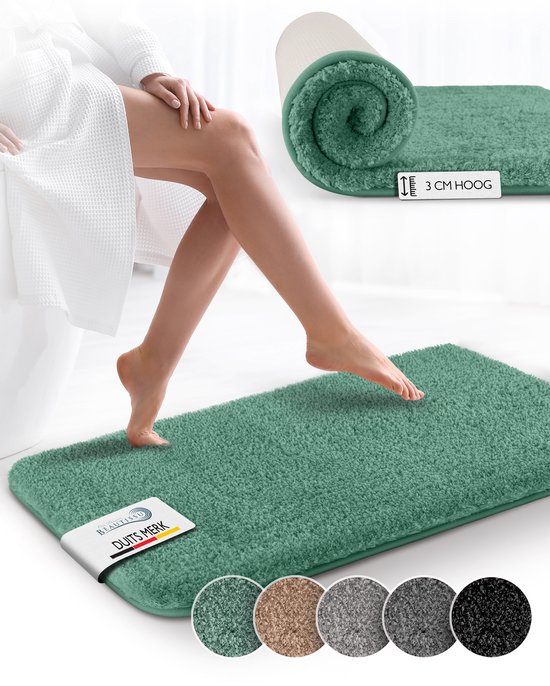 Groene, zachte badmat met 3 cm hoge pool, met een vrouw die erop stapt. Kleurstaaltjes van de mat in vier andere kleuren onderaan.