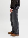 Zijaanzicht van een grijze jeans met bruine schoenen.
