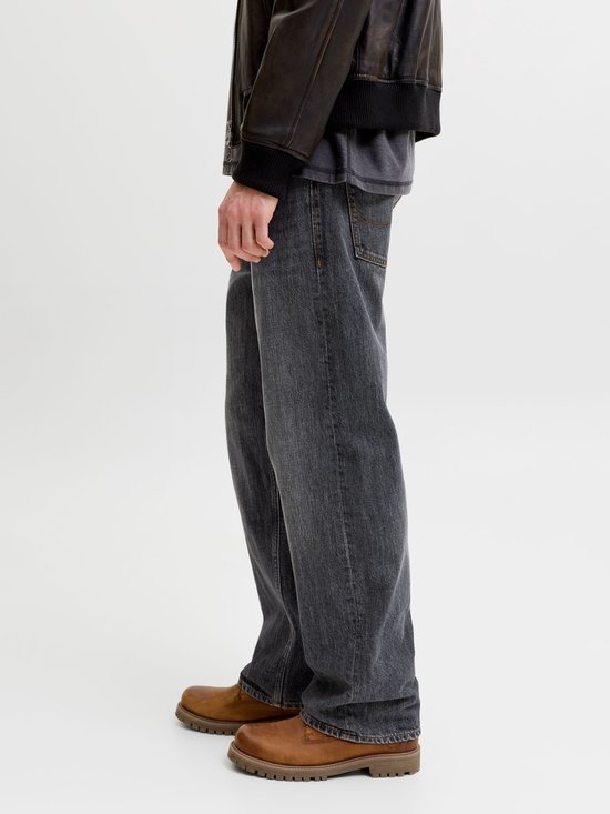 Zijaanzicht van een grijze jeans met bruine schoenen.