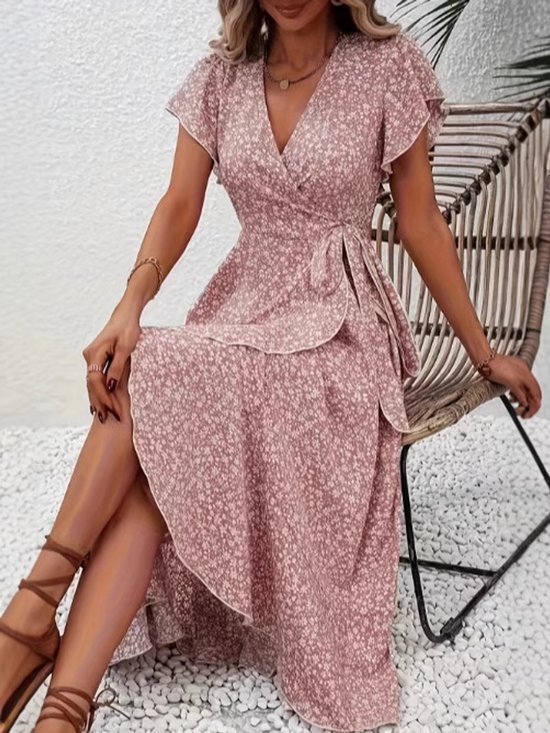 Vrouwen zitten in een roze midi wikkeljurk met kleine bloemenprint, vlindermouwen en strikceintuur.