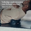 Een man met een donkere huidskleur die op de grond ligt en de WaveRoller gebruikt om zijn rug te masseren. De roller is 31 cm lang.