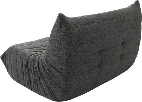Grijze vloersofa met zachte bekleding, bekeken vanaf de achterkant op witte achtergrond.