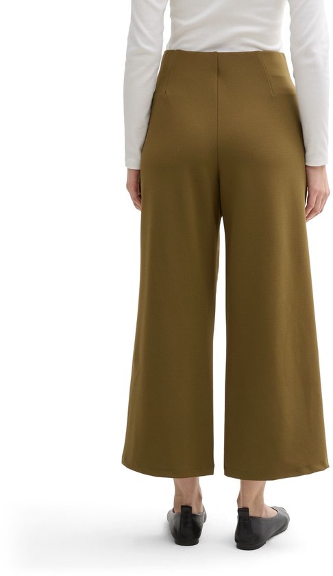 Model draagt de olijfgroene culotte, achterkant zichtbaar. De broek heeft wijde pijpen en een hoge taille.