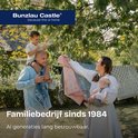 Une famille dans un jardin, avec un père portant son fils sur ses épaules, une mère avec un bébé, et du linge séchant sur une corde.