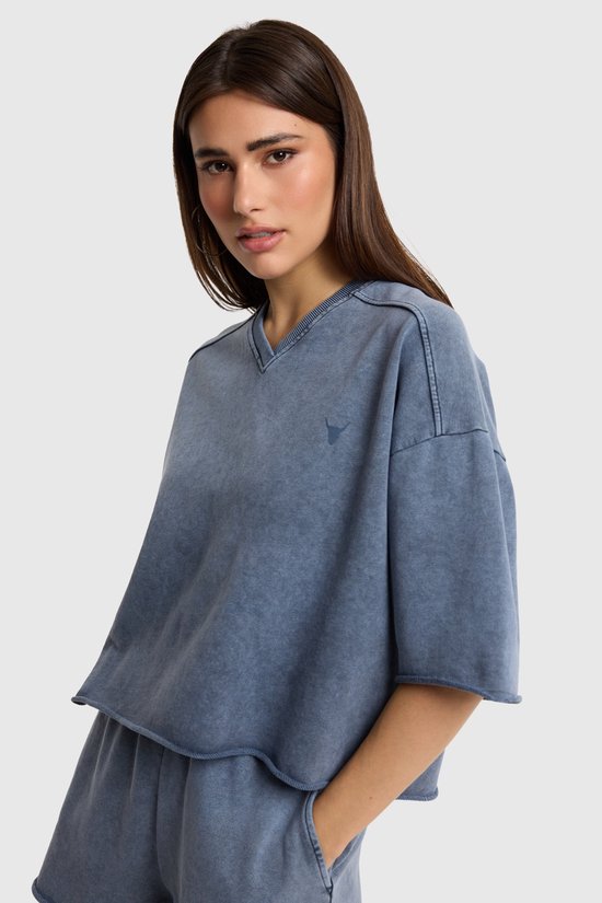 Blauw geknipte casual top met korte mouwen en een V-hals met een geborduurd logo.