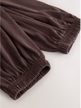 Bruine ballonbroek met elastische manchetten en ceintuur.