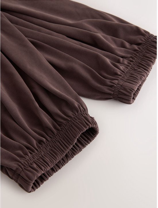 Bruine ballonbroek met elastische manchetten en ceintuur.