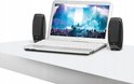 Zwarte Logitech speakers naast een laptop waarop een concert wordt getoond.