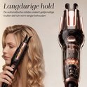 Vrouw met lang blond haar gebruikt een zwarte en roségouden automatische krultang.