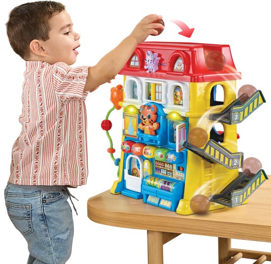 Jongetje speelt met kleurrijk speelhuis met een glijbaan, ballen en dierenfiguren.