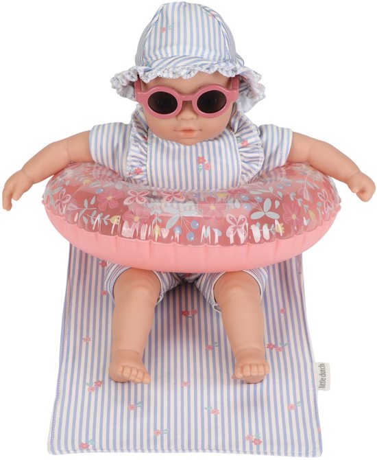 Pop met gestreept zwempak, zonnebril, hoedje, zwemband en liggend op een mat.