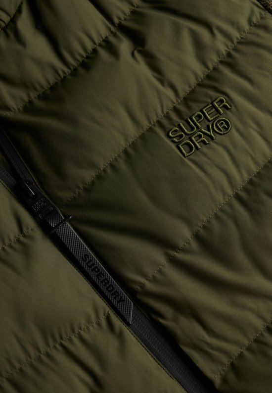 Detail van de olijfgroene jas met Superdry logo op het gewatteerde voorpand en rits.