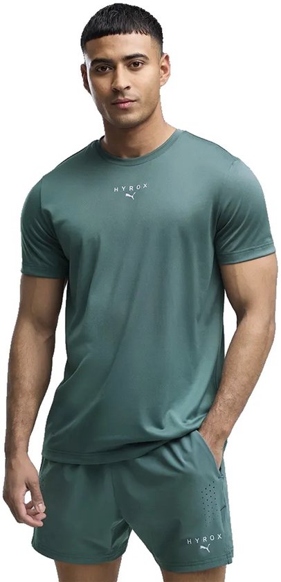Man in een groen Puma X Hyrox sportshirt met korte mouwen en bijpassende shorts. Het shirt heeft een klein logo op de borst.