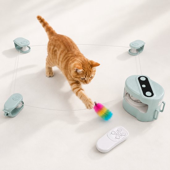 Oranje kat met speelgoeddispenser, vier clips en afstandsbediening op witte achtergrond.