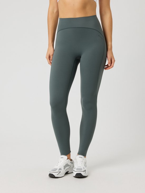 Gros plan d'un legging de sport vert foncé. Le legging a une taille haute et un logo Björn Borg brodé sur la hanche gauche.