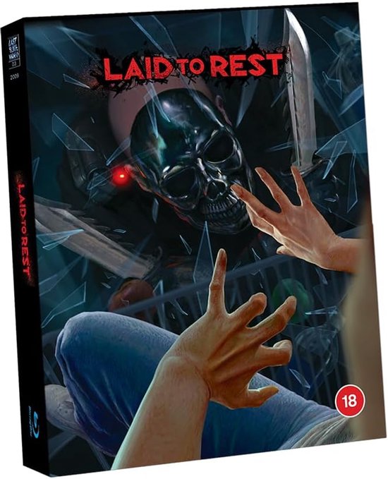 Boekomslag met de tekst 'LAID TO REST' en een dreigende schedel met mes. Een persoon met gescheurde kleding wordt vastgehouden.
