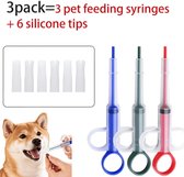 Drie pillenspuiten in blauw, grijs en rood, naast zes siliconen tips. Een hond krijgt een pil uit een spuit.